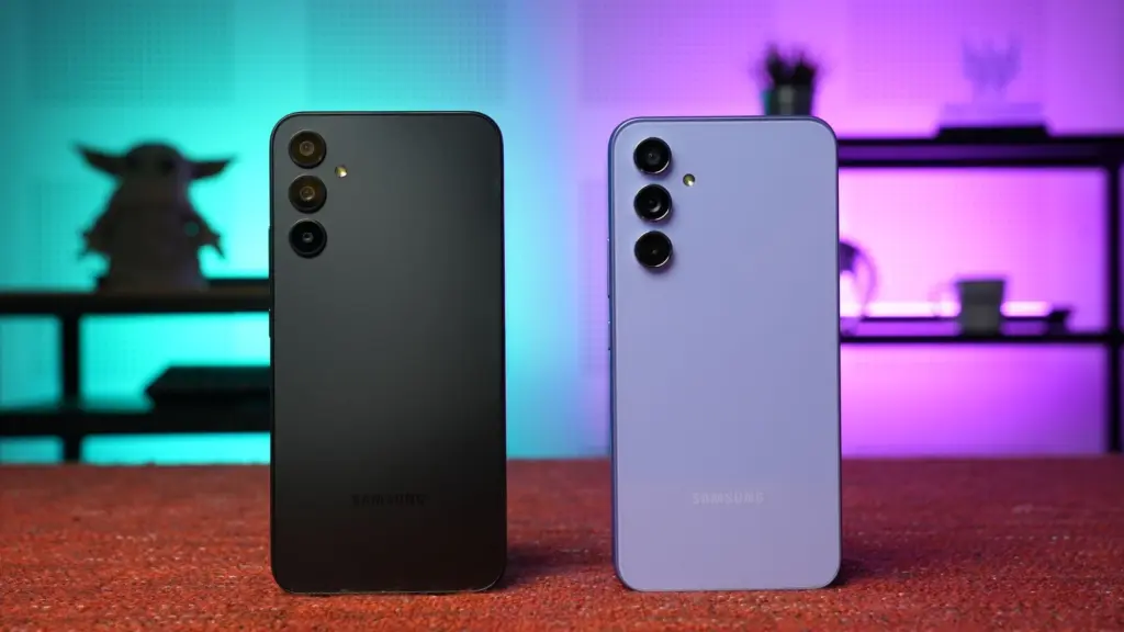 Two Samsung smartphones shown from the back on a red surface, black and lavender finishes with multiple rear cameras and a neon backdrop.