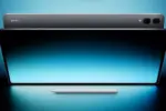 Promotional image of a Samsung tablet with a stylus placed below, glowing blue backdrop, showcasing a large edge-to-edge screen and circular camera module on top edge (no people).
