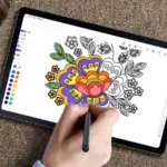 Tablet on carpet, hand using a stylus to color a floral design in a digital coloring app; color palette along the edge is visible.
