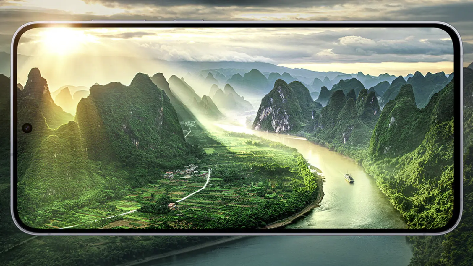 Smartphone screen showing a sunlit valley with green karst mountains and a winding river