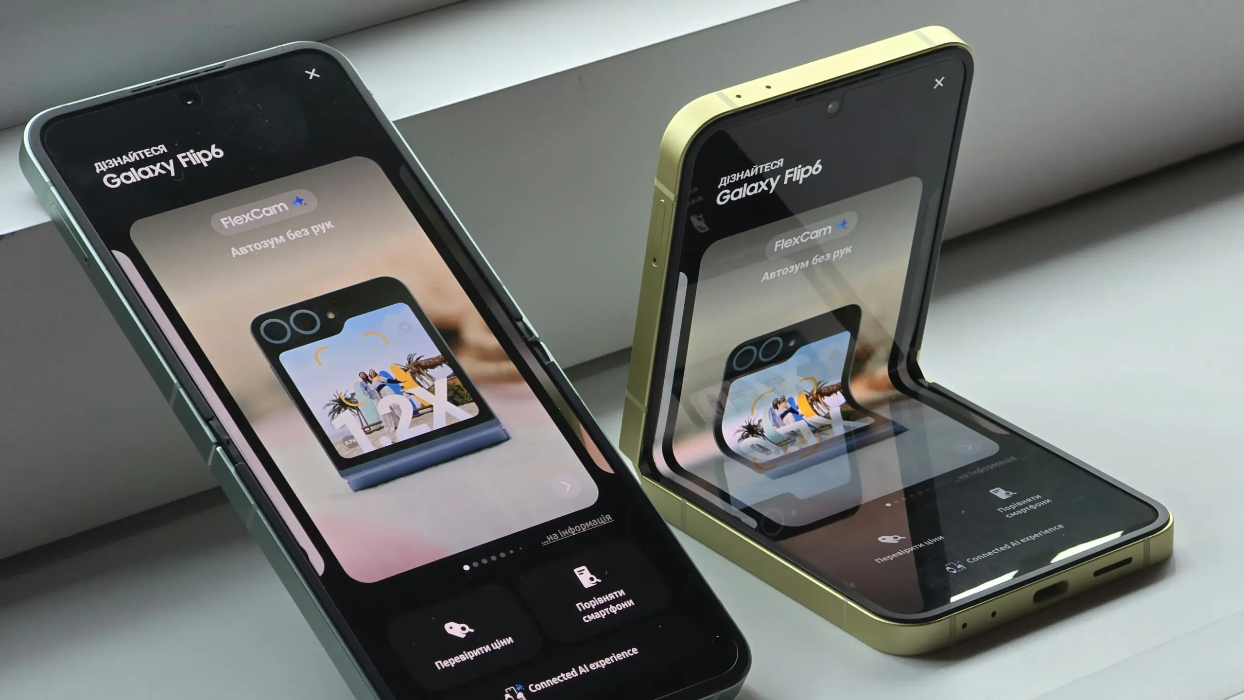 Two Galaxy Flip foldable smartphones in green and gold sit on a light surface, screens showing a FlexCam promo and Cyrillic text.