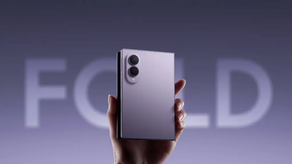 A hand holding a foldable smartphone with a dual-camera module on the back.
