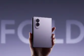 A hand holding a foldable smartphone with a dual-camera module on the back.