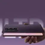 Hand holding a foldable smartphone with a triple-camera array against a purple background.