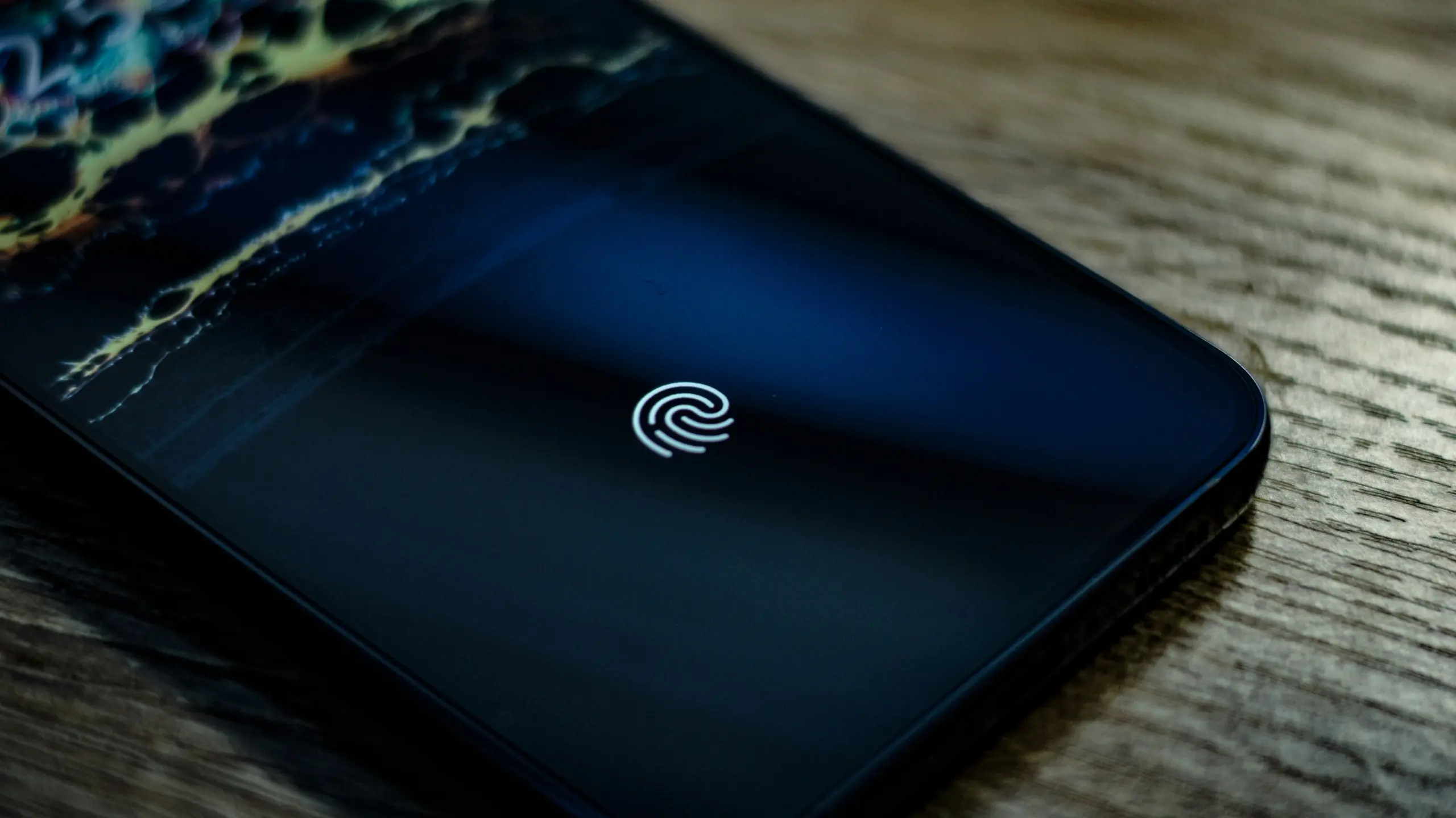 Close-up of a black smartphone back with a white fingerprint authentication emblem indicating biometric unlock
