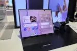 Galaxy Z Fold8 on a display stand, showing a large folded screen with app icons and widgets on a purple UI.