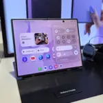 Galaxy Z Fold8 on a display stand, showing a large folded screen with app icons and widgets on a purple UI.