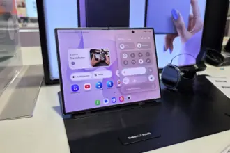 Galaxy Z Fold8 on a display stand, showing a large folded screen with app icons and widgets on a purple UI.