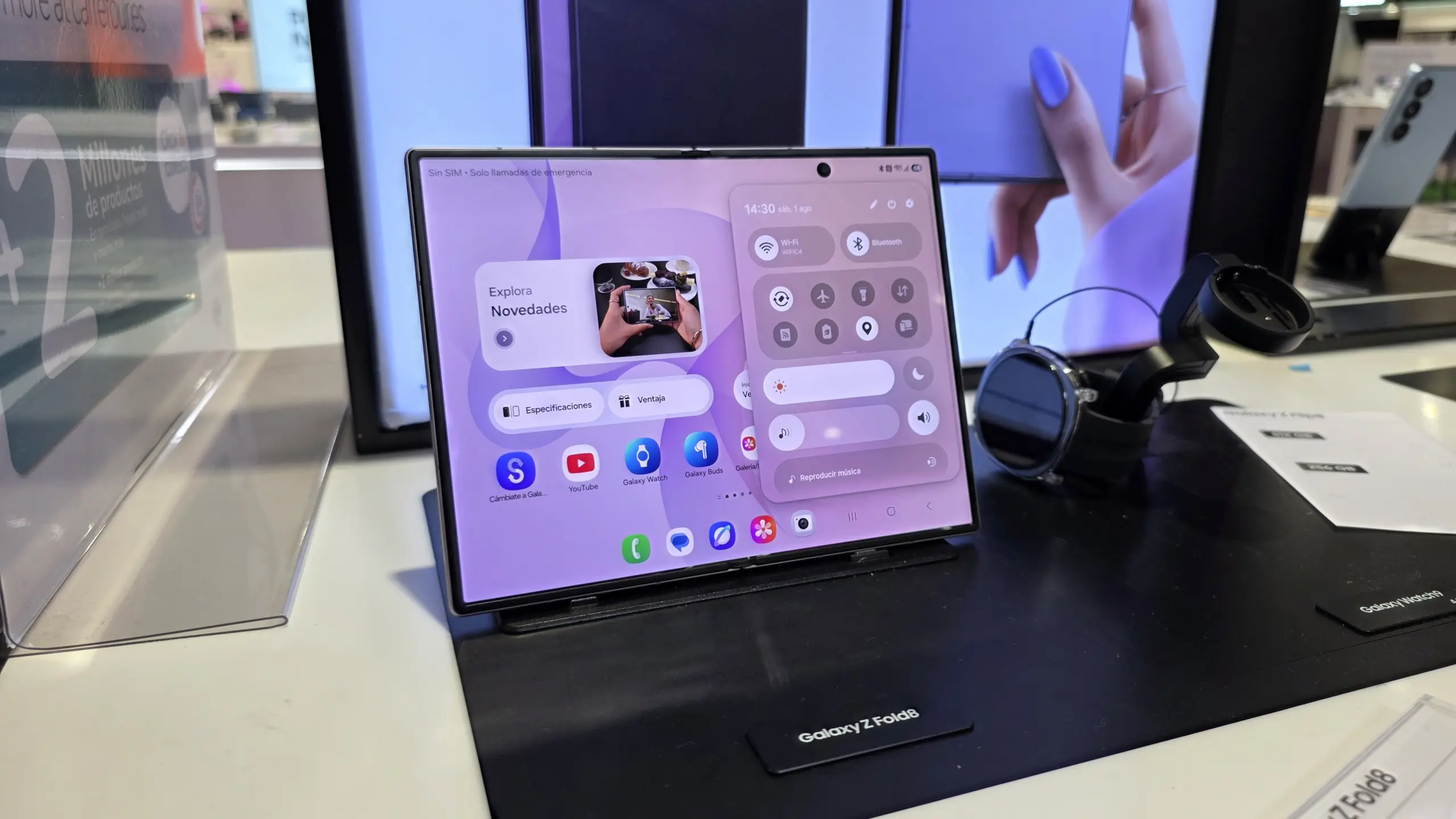 Galaxy Z Fold8 on a display stand, showing a large folded screen with app icons and widgets on a purple UI.